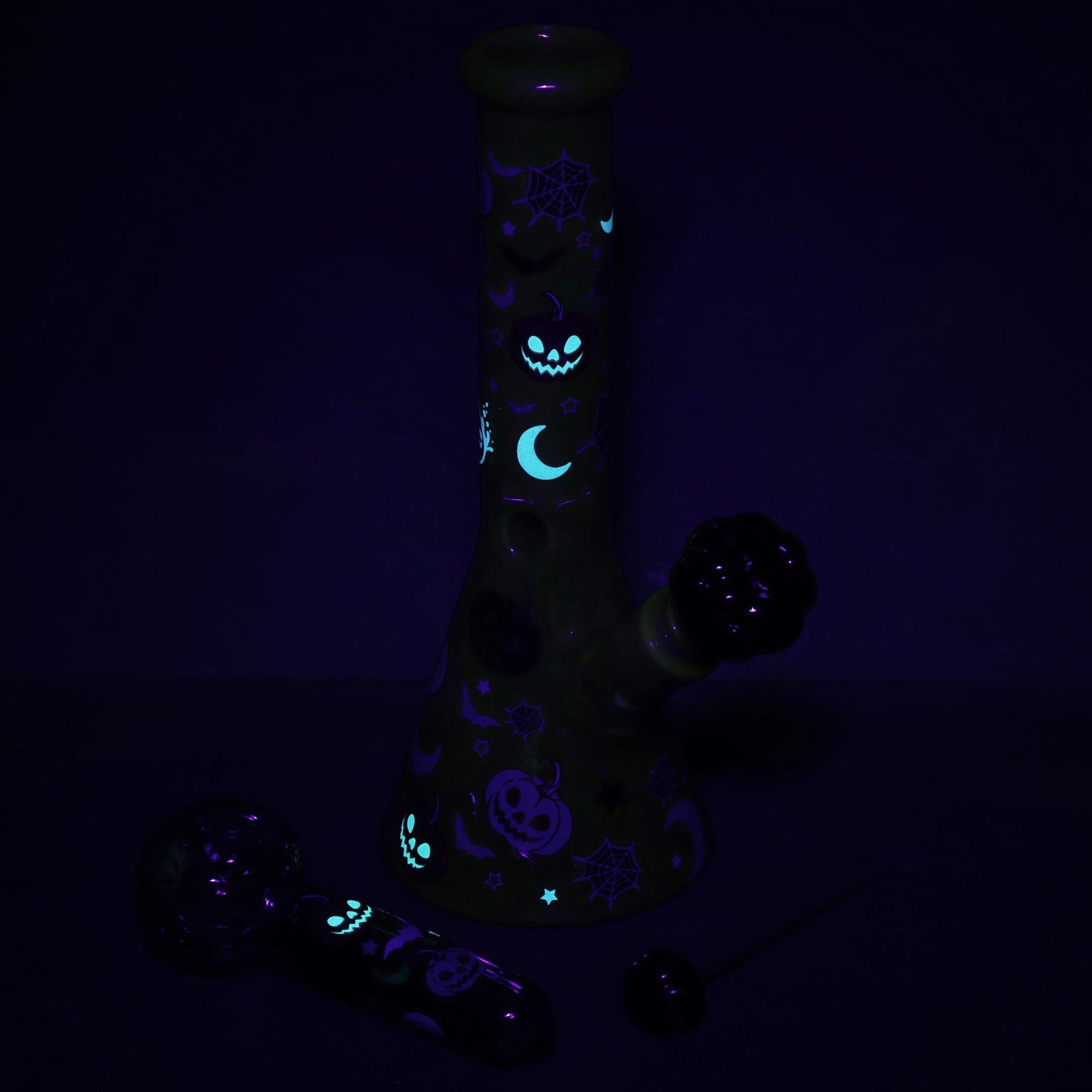 Halloween Party Bong Glow Duo glowing in the dark, showcasing spooky glow-in-the-dark accents on bong and hand pipe